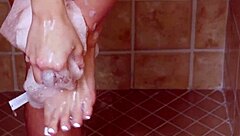 A young brunette girl takes a shower and gets some more than just water on her body