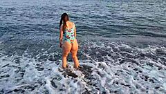 Horny teen shows off her big ass on the public beach, getting her pussy exposed outdoors