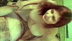 Young beauty with red hair poses naked in a homemade video