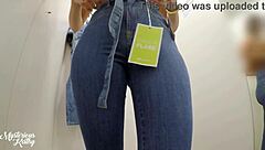 Brazilian beauty with small waist tries on jeans in changing room