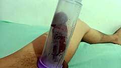 A gay man uses a penis pump while giving a blowjob