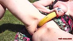 red xxx shoves banana in mature pussy outdoors