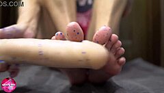 Beautiful woman gives a sensual footjob to a man with a rubber cock - foot fetish
