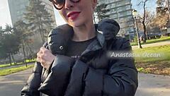Beautiful woman shows her big breasts while walking in the park