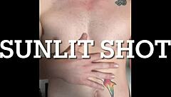 Twink jerks big cock in sunlight, contrasting innocence and lust.