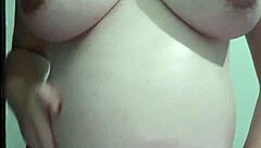 A pregnant woman is being massaged with cream on her belly