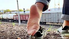 i tease my tan nylon soles in blue jeans on the bench outdoors