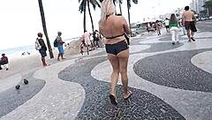 Sexy milf blonde flashes in mini short on Copacabana beach with guys staring