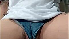 Watch this naughty babe flaunt her huge clit and hairy pussy in tight jeans shorts - no panties!