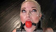 blonde woman locked in a device riding a sybian machine