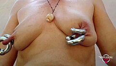 nippleringlover's kinky mother pumping pierced tits, inserting big double rings in extreme pierced nipples outdoors?