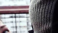 Teen is sucking something on the roof of a building in public