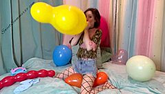 Skinny brunette girl inflates and pops giant balloon with her mouth