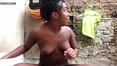Black bahian teen taking a bucket bath in the backyard