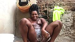 Black bahian teen taking a bucket bath in the backyard