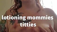 applying lotion to mature boobs