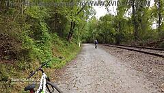 Athletic Brunette Rides Bike in Public Park