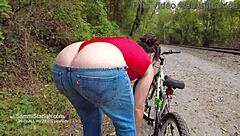 Athletic Brunette Rides Bike in Public Park