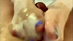 A wife gives a handjob to her husband while he's with another woman, wearing stockings and jerking off her feet until she cums