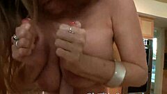 A fiery-haired mature woman enthusiastically engages in a tit-job on a massive shaft.