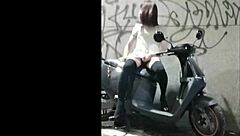 Chinese shemale masturbates outdoors, shooting cum in wild exposure scene.