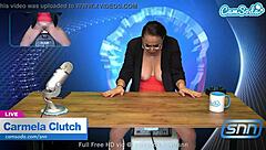 A sultry mature woman with ample bust pleasures herself on camera while watching the news