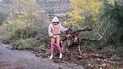 A woman masturbates outdoors near the mountains, reaching orgasm in the fresh air.