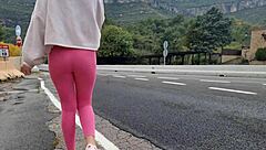 A woman masturbates outdoors near the mountains, reaching orgasm in the fresh air.
