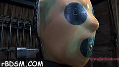 the caged brunette babe uses toys for masturbation before giving a blowjob to her masked slave master