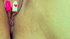 Petite young girl fingers her shaved pussy intensely in close-up.