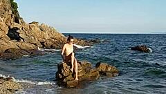 Naked Latina inserts pebbles on public beach solo walk
